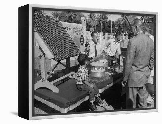 Salesman Demonstrating Solar Battery at the International Conference on Solar Energy-J^ R^ Eyerman-Framed Premier Image Canvas