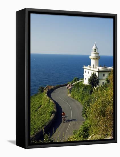 San Sebastian Bay Clifftop Lighthouse with Cyclist Riding Uphill-Christian Kober-Framed Premier Image Canvas