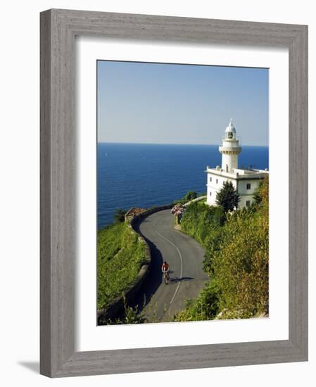 San Sebastian Bay Clifftop Lighthouse with Cyclist Riding Uphill-Christian Kober-Framed Photographic Print