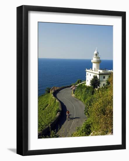 San Sebastian Bay Clifftop Lighthouse with Cyclist Riding Uphill-Christian Kober-Framed Photographic Print