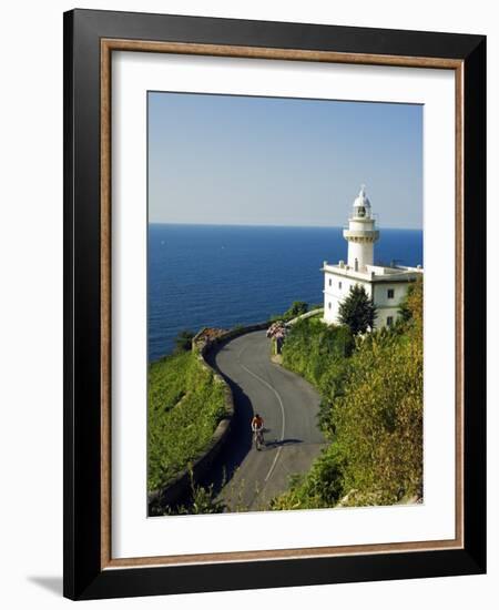 San Sebastian Bay Clifftop Lighthouse with Cyclist Riding Uphill-Christian Kober-Framed Photographic Print