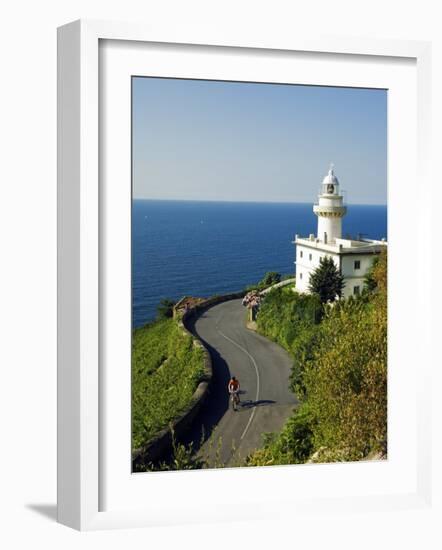 San Sebastian Bay Clifftop Lighthouse with Cyclist Riding Uphill-Christian Kober-Framed Photographic Print