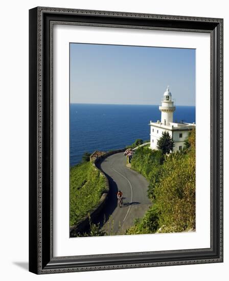 San Sebastian Bay Clifftop Lighthouse with Cyclist Riding Uphill-Christian Kober-Framed Photographic Print