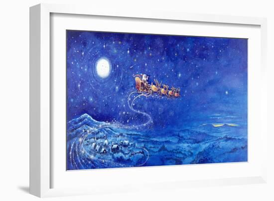 Santa in Night Sky over Winter Village in Sleigh Pulled by Reindeer-Bill Bell-Framed Giclee Print