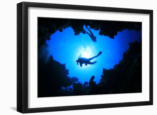 Scuba Divers Descend into an Underwater Cavern. Silhouettes against Sunburst-Rich Carey-Framed Photographic Print