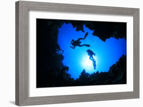 Scuba Divers Descend into an Underwater Cavern. Silhouettes against Sunburst-Rich Carey-Framed Photographic Print