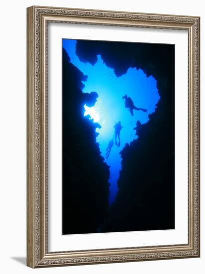 Scuba Divers Descend into Underwater Cavern, Silhouetted against Sun-Rich Carey-Framed Photographic Print