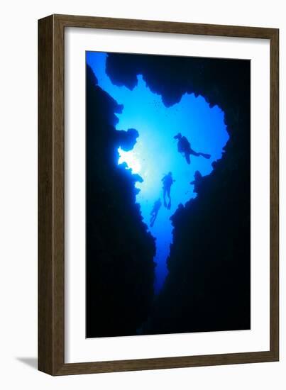 Scuba Divers Descend into Underwater Cavern, Silhouetted against Sun-Rich Carey-Framed Photographic Print