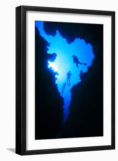 Scuba Divers Descend into Underwater Cavern, Silhouetted against Sun-Rich Carey-Framed Photographic Print