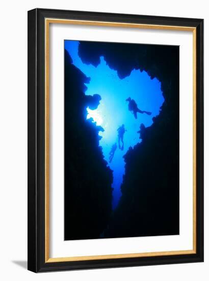 Scuba Divers Descend into Underwater Cavern, Silhouetted against Sun-Rich Carey-Framed Photographic Print