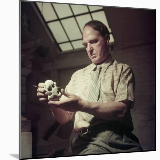 Sculptor Henry Moore Holding a Small Sculpture in His Studio in Much Hadham, England-Gjon Mili-Mounted Premium Photographic Print