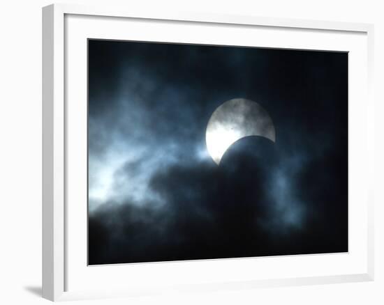 Seen Through Clouds the Sun is Partially Obscured by the Moon During an Eclipse-null-Framed Photographic Print