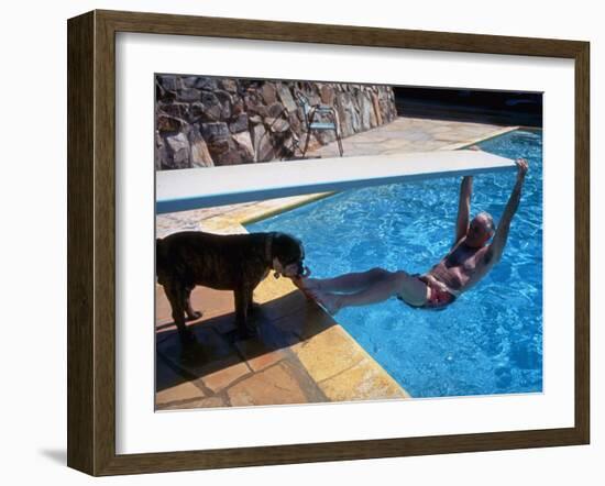 Sen. Barry Goldwater Hanging Underneath Diving Board in Swimming Pool as Dog Licks His Toes-Bill Ray-Framed Photographic Print