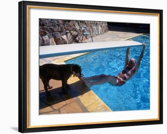 Sen. Barry Goldwater Hanging Underneath Diving Board in Swimming Pool as Dog Licks His Toes-Bill Ray-Framed Photographic Print