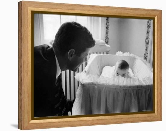 Sen. Jack Kennedy Admiring Baby Caroline as She Lies in Her Crib in Nursery at Georgetown Home-Ed Clark-Framed Premier Image Canvas