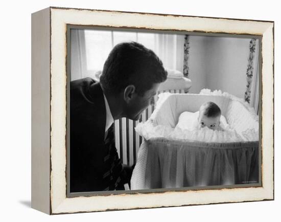 Sen. Jack Kennedy Admiring Baby Caroline as She Lies in Her Crib in Nursery at Georgetown Home-Ed Clark-Framed Premier Image Canvas