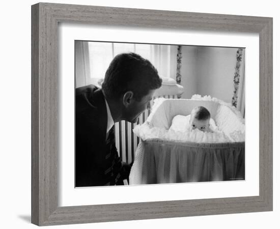 Sen. Jack Kennedy Admiring Baby Caroline as She Lies in Her Crib in Nursery at Georgetown Home-Ed Clark-Framed Photographic Print