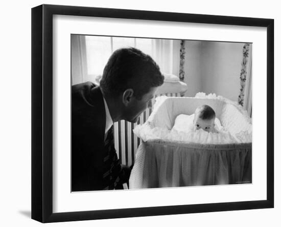 Sen. Jack Kennedy Admiring Baby Caroline as She Lies in Her Crib in Nursery at Georgetown Home-Ed Clark-Framed Photographic Print