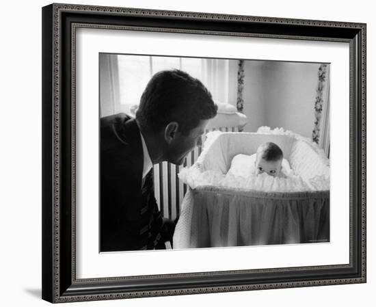 Sen. Jack Kennedy Admiring Baby Caroline as She Lies in Her Crib in Nursery at Georgetown Home-Ed Clark-Framed Photographic Print