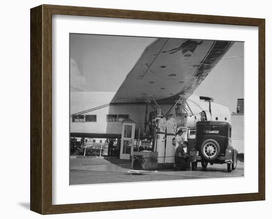 Service Attendant Pumping Gasoline Into Ford Sedan as Woman Watches at Gas Pumps-Peter Stackpole-Framed Photographic Print