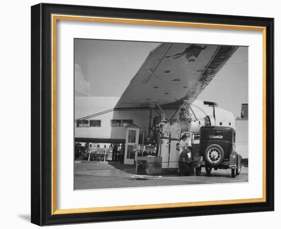 Service Attendant Pumping Gasoline Into Ford Sedan as Woman Watches at Gas Pumps-Peter Stackpole-Framed Photographic Print