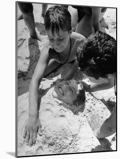 Settlement House Children Burying Boy under Sand at the Beach-Martha Holmes-Mounted Photographic Print