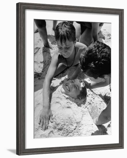 Settlement House Children Burying Boy under Sand at the Beach-Martha Holmes-Framed Photographic Print