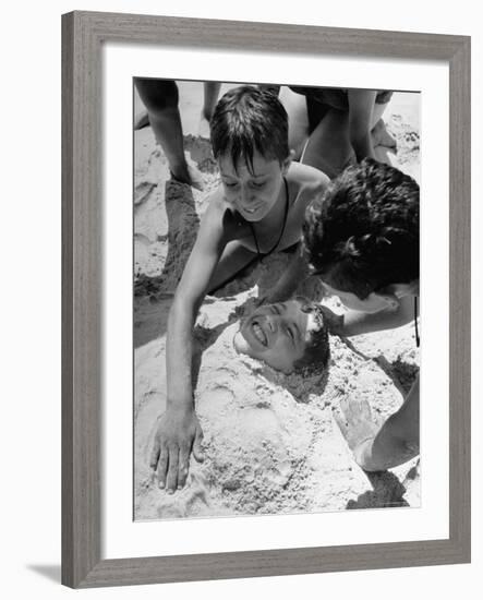 Settlement House Children Burying Boy under Sand at the Beach-Martha Holmes-Framed Photographic Print