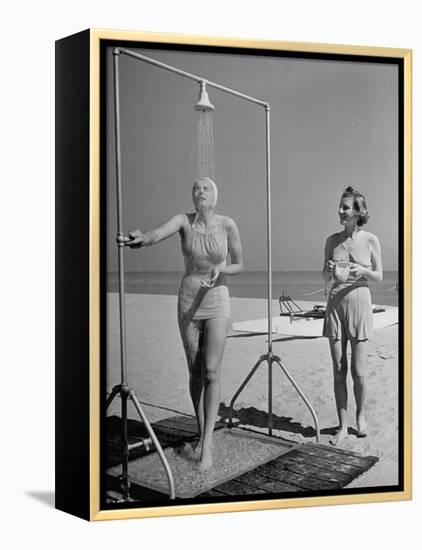 Shapely Sunbather Taking an Outdoor Shower as Woman Preparing for Her Turn, Looks On, at Beach-Alfred Eisenstaedt-Framed Premier Image Canvas