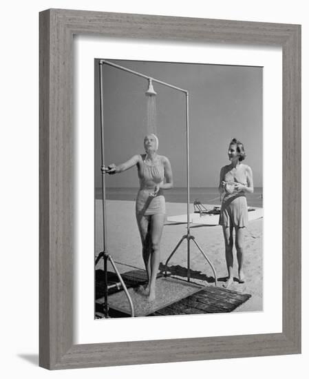 Shapely Sunbather Taking an Outdoor Shower as Woman Preparing for Her Turn, Looks On, at Beach-Alfred Eisenstaedt-Framed Photographic Print