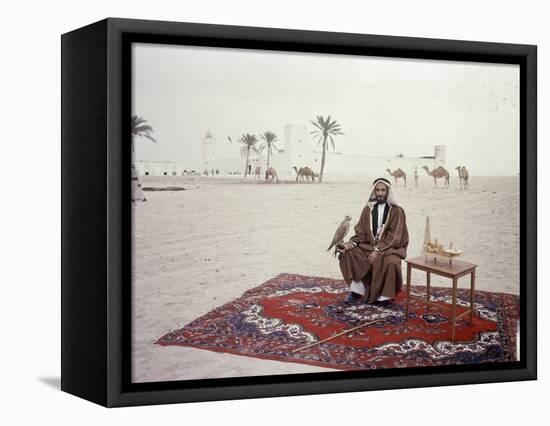 Sheikh Shakhbut Bin Sultan Al Nahyan Sitting in Front of His Palace Holding a Falcon, 1963-Ralph Crane-Framed Premier Image Canvas