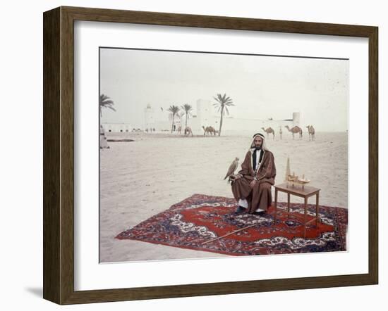 Sheikh Shakhbut Bin Sultan Al Nahyan Sitting in Front of His Palace Holding a Falcon, 1963-Ralph Crane-Framed Photographic Print