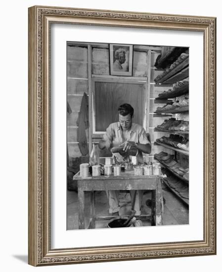 Shoemaker Sitting in His Shop Working on a Pair of Old Work Shoes-John Phillips-Framed Photographic Print