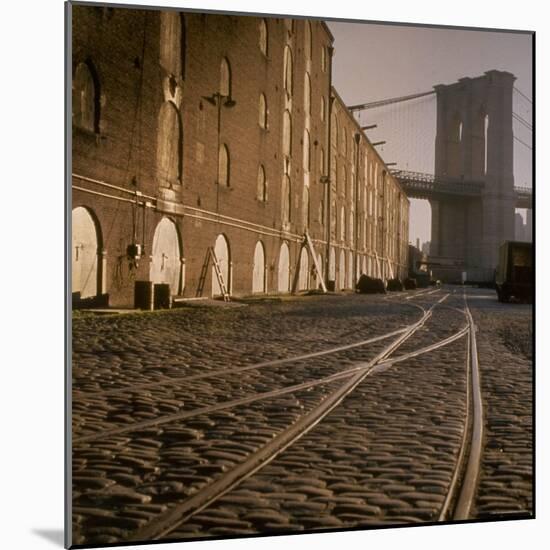 Shuttered Warehouses Lit by Sunlight on Trolley Track Railed Street Along Brooklyn Waterfront-Walker Evans-Mounted Photographic Print