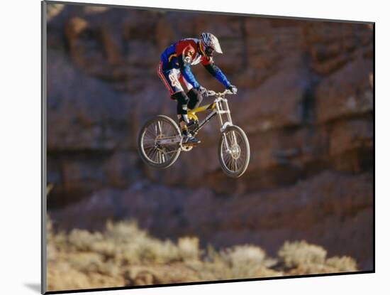 Side Profile of a Person on a Bicycle in Mid Air-null-Mounted Photographic Print