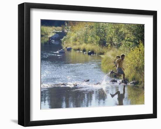 Side Profile of a View of a Young Man Running Across a River-null-Framed Photographic Print