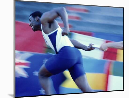 Side Profile of Runners Passing a Baton in a Relay Race-null-Mounted Photographic Print