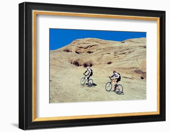 Side profile of two men mountain bilking on rocks, Slickrock Trail, Moab, Utah, USA-Richard Sisk-Framed Photographic Print