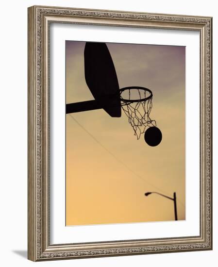 Silhouette of a Basketball Going Through a Basketball Net-null-Framed Photographic Print