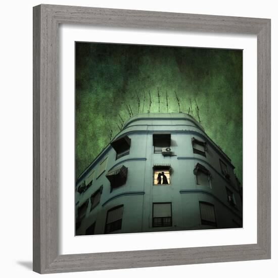 Silhouette of a Man and Woman Kissing in a Window of a Large Building with TV Ariels on the Roof-Luis Beltran-Framed Photographic Print