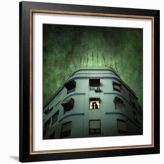 Silhouette of a Man and Woman Kissing in a Window of a Large Building with TV Ariels on the Roof-Luis Beltran-Framed Photographic Print