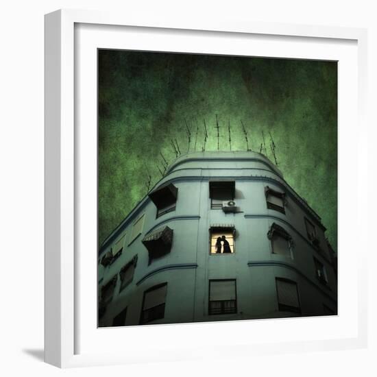 Silhouette of a Man and Woman Kissing in a Window of a Large Building with TV Ariels on the Roof-Luis Beltran-Framed Photographic Print