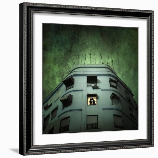 Silhouette of a Man and Woman Kissing in a Window of a Large Building with TV Ariels on the Roof-Luis Beltran-Framed Photographic Print