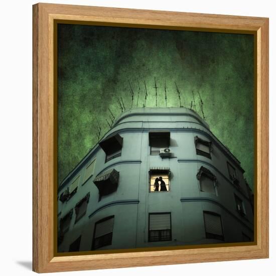 Silhouette of a Man and Woman Kissing in a Window of a Large Building with TV Ariels on the Roof-Luis Beltran-Framed Premier Image Canvas