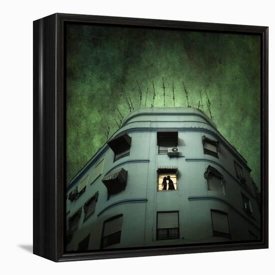 Silhouette of a Man and Woman Kissing in a Window of a Large Building with TV Ariels on the Roof-Luis Beltran-Framed Premier Image Canvas