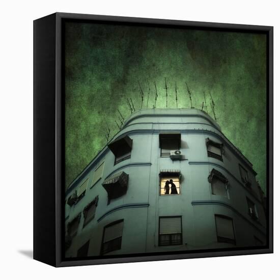 Silhouette of a Man and Woman Kissing in a Window of a Large Building with TV Ariels on the Roof-Luis Beltran-Framed Premier Image Canvas