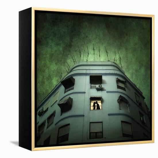 Silhouette of a Man and Woman Kissing in a Window of a Large Building with TV Ariels on the Roof-Luis Beltran-Framed Premier Image Canvas