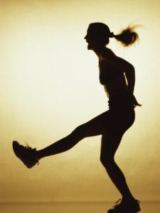Silhouette of a Young Woman Exercising