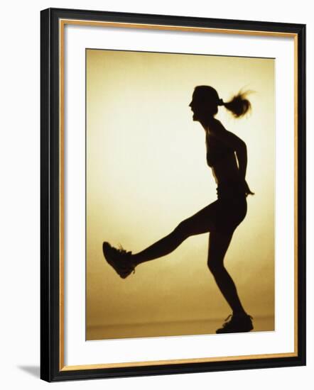 Silhouette of a Young Woman Exercising--Framed Photographic Print
