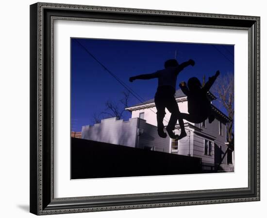 Silhouette of Children Bouncing on a Trampoline-Bill Eppridge-Framed Photographic Print